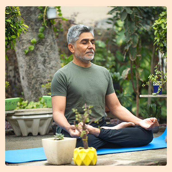 middle-aged man practicing meditation outdoors